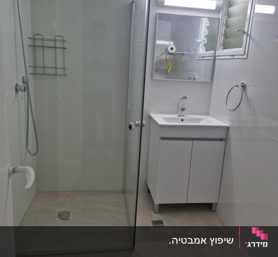 חדר אמבטיה עם מקלחון וכיור לבן
